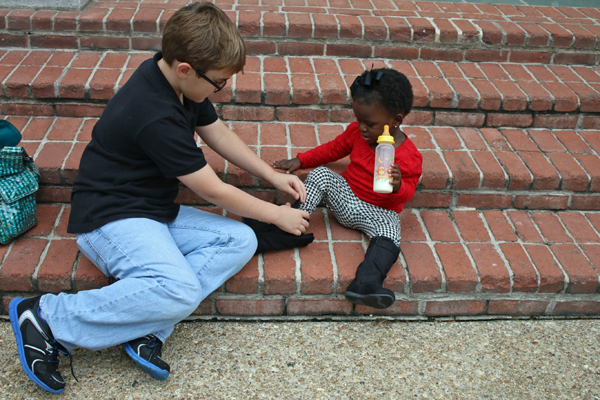 Brother helps sister with boot